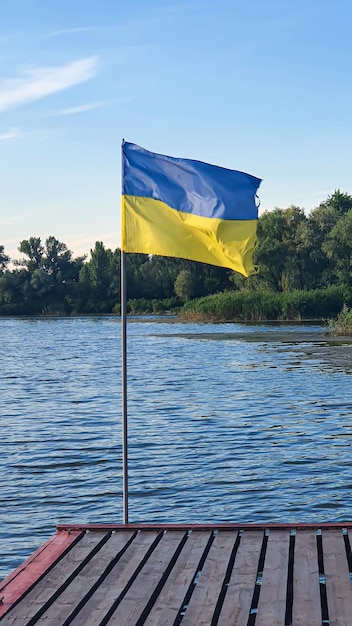 Oekraïense vlaggen wapperen op de pier van de rivier zonnige zomerdag symbolen van oekraïne