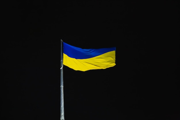 Foto oekraïne blauwe en gele vlag wapperen in de wind tegen de nachtelijke hemel nationaal oekraïens symbool