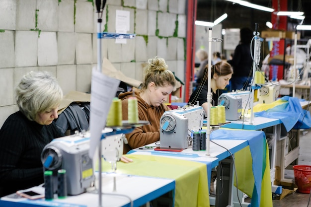 OEKRANE ROVNO 28 februari Vrijwilligers naaien de vlag van Oekraïne tijdens de fabrieksoorlog in Oekraïne