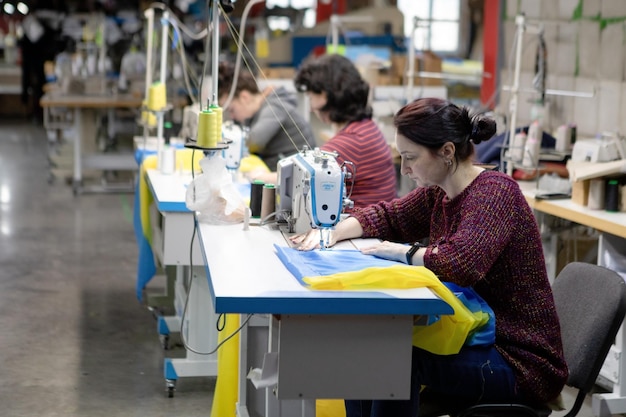 OEKRANE ROVNO 28 februari Vrijwilligers naaien de vlag van Oekraïne tijdens de fabrieksoorlog in Oekraïne