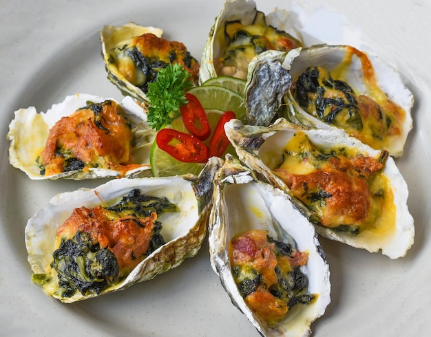 Oesters gebakken met 3 kazen op witte plaat close-up