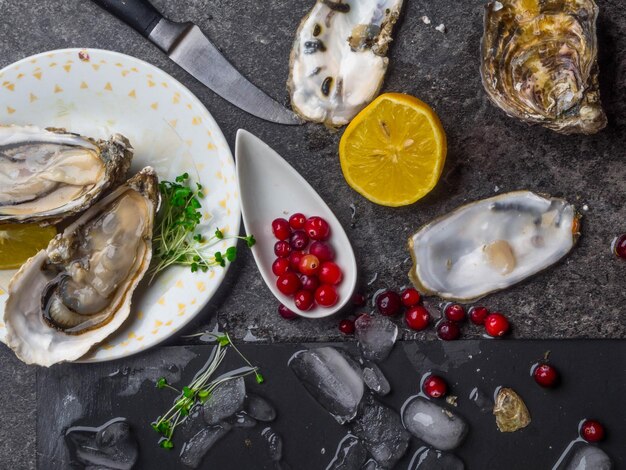 Oesters hartvorm in plaat met citroen veenbessen microgreens mes schelpen op marmer