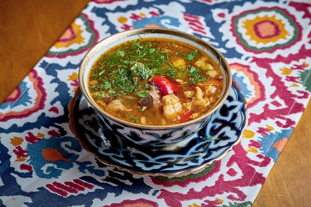 Oezbeekse chuchvara met tomatensaus en groenten geserveerd in bord. Joshpara is een soort knoedel