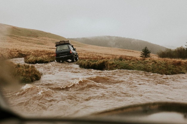 Foto off-road auto vast in de waterstroom in de natuur