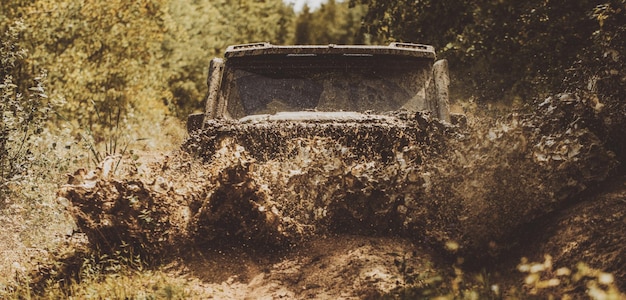 Off road sport truck between mountains landscape offroad\
vehicle coming out of a mud hole hazard dra