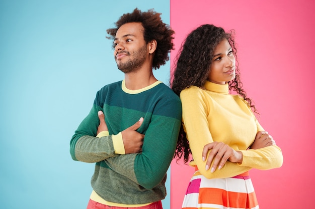 Offended young couple standing with arms crossed