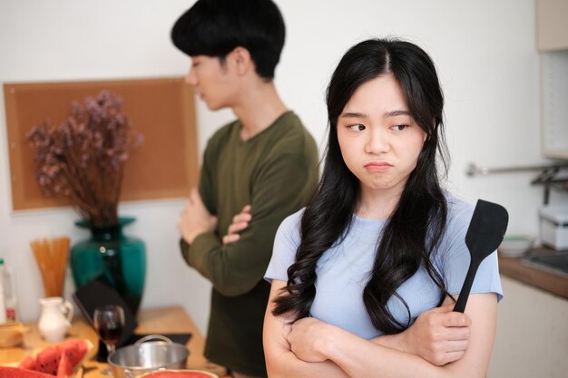 Photo offended young woman ignoring her upset husband after quarrel in kitchen negative emotions relationship problems