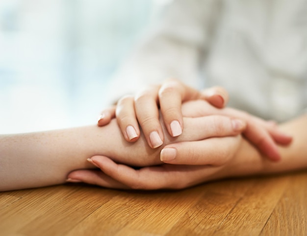 Offering support and comfort Shot of two people holding hands in comfort