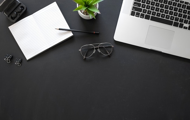 Office black workspace with office supplies on black background, flat lay, copy space