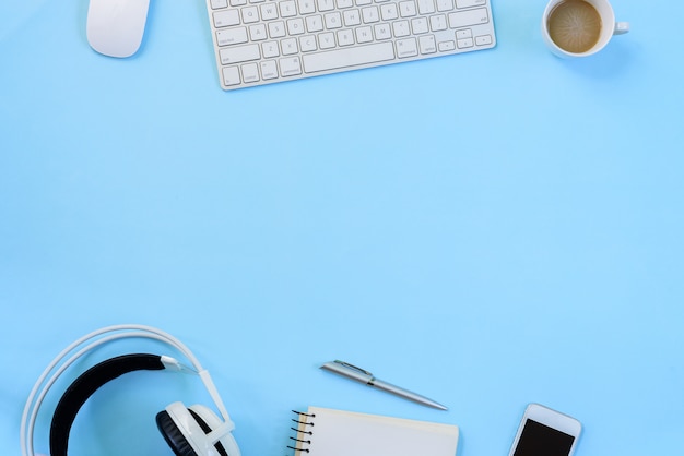 The office blue desk and equipment for working in top view and flat lay on blue background