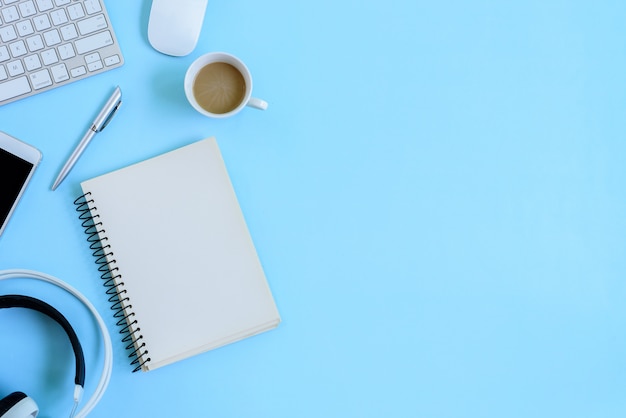 The office blue desk and equipment for working in top view and flat lay on blue background