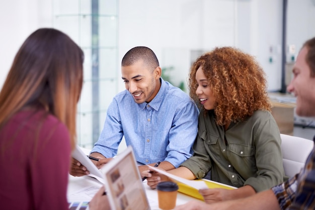 Office brainstorming and business people in meeting cooperation and ideas with laptop paperwork and speaking Design agency staff or group with technology support and collaboration for project