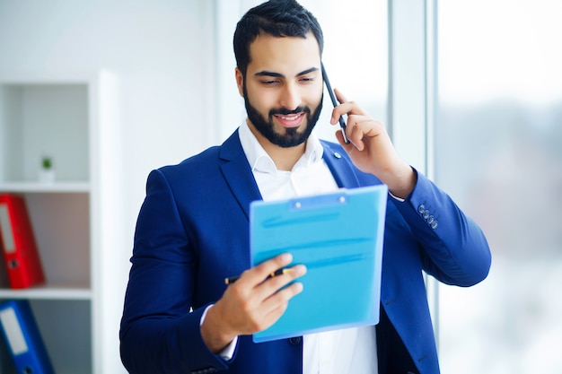 Office Business Man in a Light Office with Big Windows Holding a