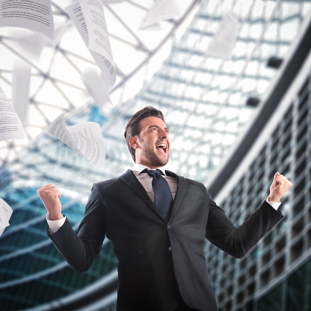 In the office businessman exults throwing sheets