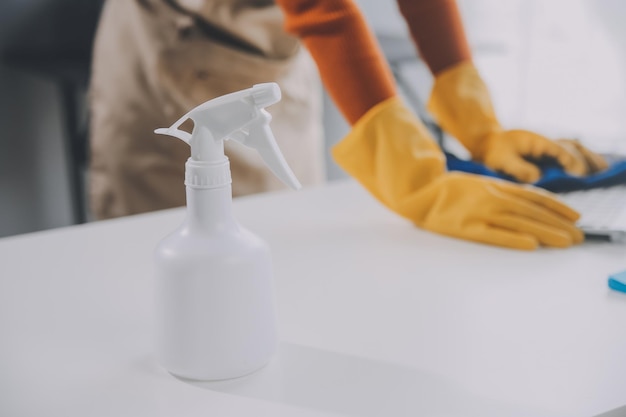 Photo office cleaning service janitor spraying desk workplace hygiene