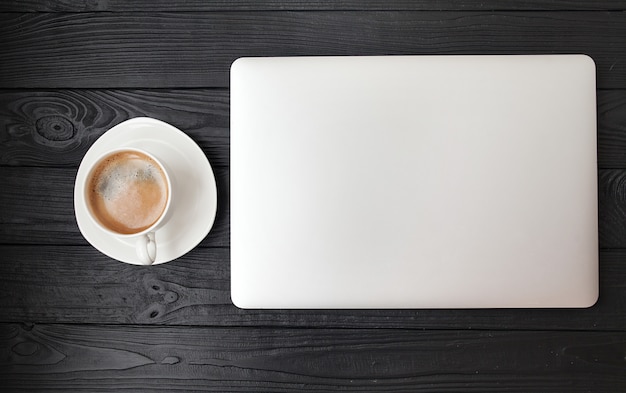 Office desk - Laptop computer and coffee cup on wood texture and background with copy space.