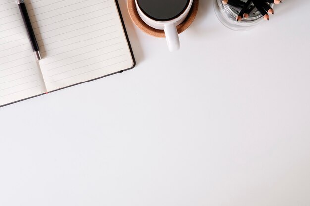 Office desk notebook paper, pen and coffee cup, A top view copy space.