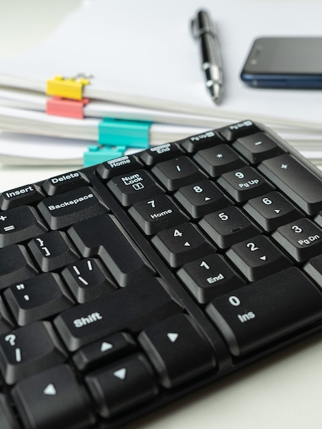 Office desk table with computer keyboard and supplies. On white background. Copy space.