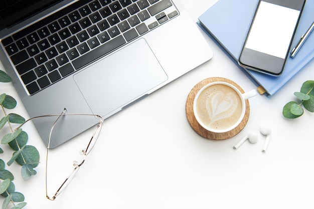 Office desk table with laptop supplies and coffee cup