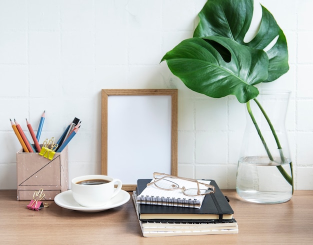 Office desk table with  notebooks, supplies and coffee cup.