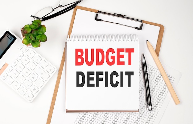 Office desk table with paper sheet notepad chart and calculator Top view BUDGET DEFICIT