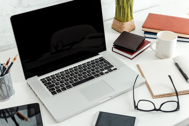 Office desk. top view of comfortable working place in office\
with white table and laptop laying on it