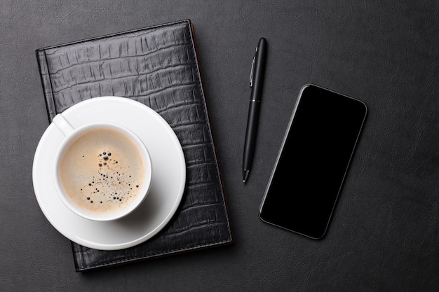 Office desk with coffee notepad phone and pen