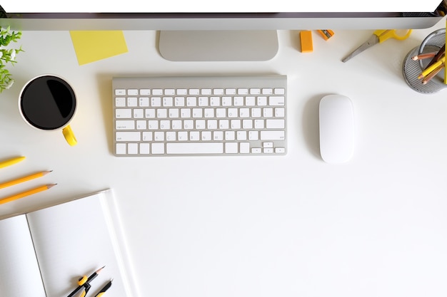 Office desk with computer keyboard, smartphone , coffee, notebook and pencil 