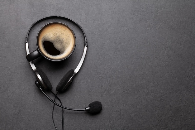 Office desk with headset and coffee cup