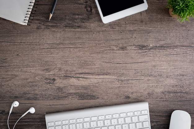 Photo office desk with keyboard, mouse, plant, and notebook