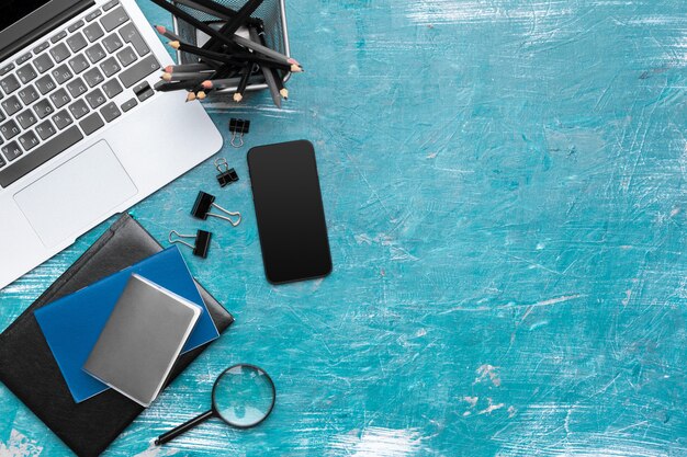 Office desk with laptop, smartphone. 