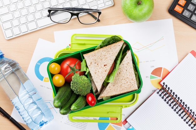 Office desk with supplies and lunch box