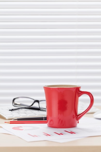 Office desk workplace with coffee and charts