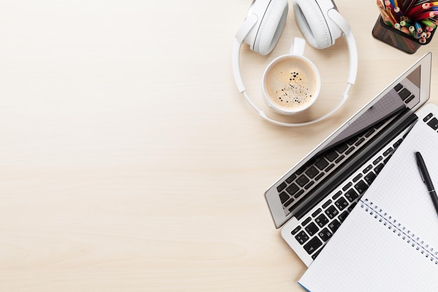 Office desk workplace with laptop coffee and headphones