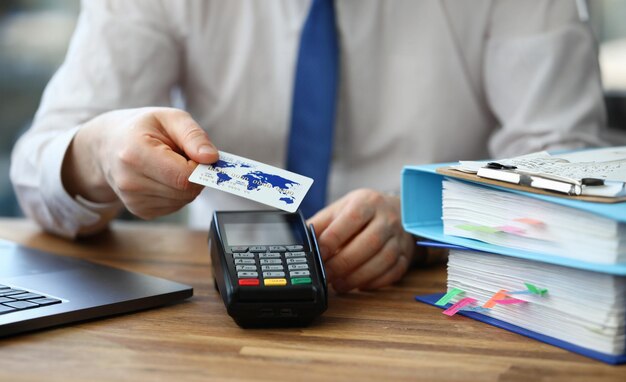 Office employee shows credit card and terminal