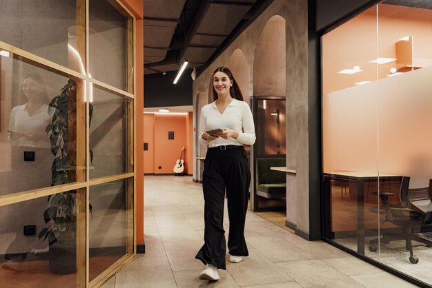 Photo an office entrepreneur a business woman in business clothes uses a tablet computer and a business