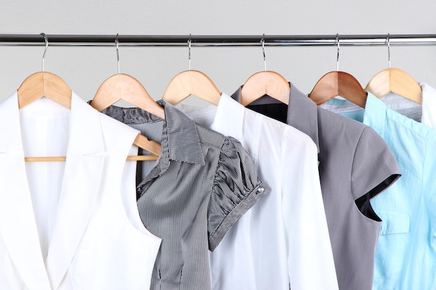 Office female clothes on hangers on gray background