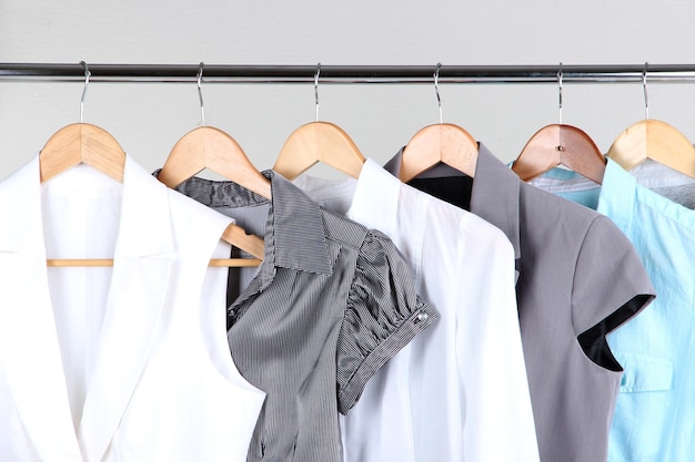 Office female clothes on hangers on gray background
