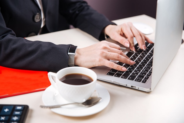 Office female hands laptop calculator coffee