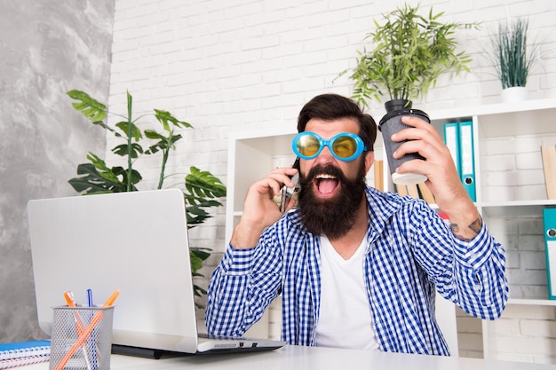 Maniaco dell'ufficio strano sul posto di lavoro uomo pazzo manager dell'ufficio che fa una telefonata mentre beve caffè giornata produttiva progetti di gestione stravaganti composizione emotiva e mentale di artisti di alto livello