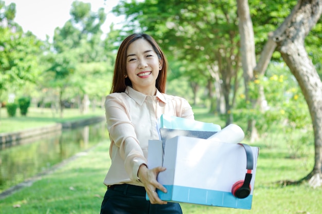 Office girl in possesso di una scatola di carta bianca, mettere file e musica cuffie sorriso felice