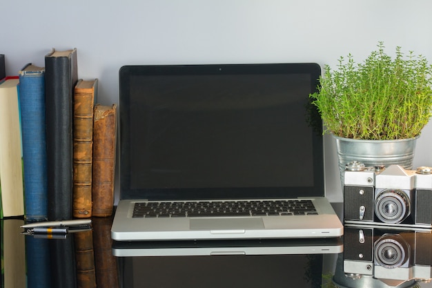 Office glass desk table with computer, flower and supplies