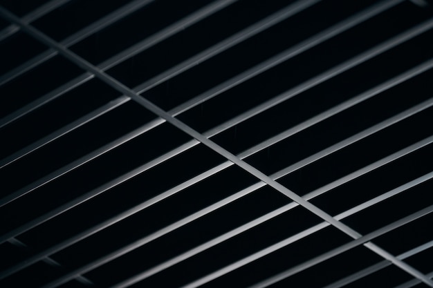 Office grille ceiling. Modern black metal grille ceiling, suspended covering. Abstract texture.