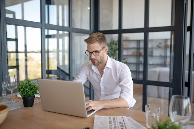 会社で。彼のコンピューターで作業しているハンサムな男