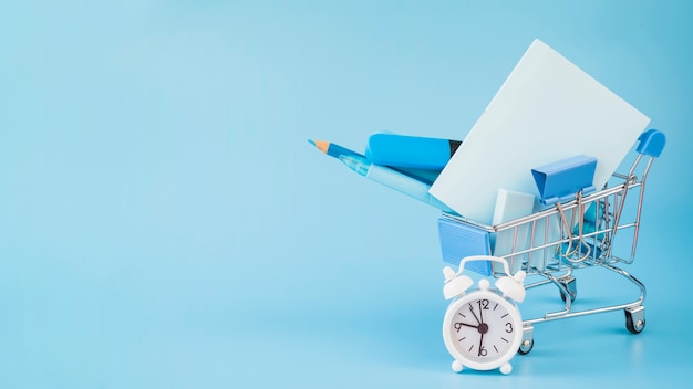 Photo office incidentals in shopping trolley and alarm clock