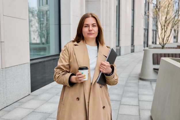 The office is on the street A business woman with a laptop is drinking coffee outside Office employee