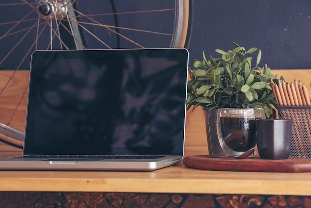 Office laptop business financial document chart and graph on wooden table with coffee cup. Flat lay notebook computer laptop on office desk. No people business graph chart mockup on business workspace