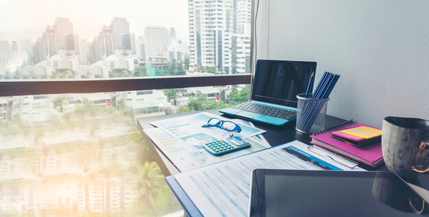 Photo office laptop business financial document chart and graph on wooden table with coffee cup