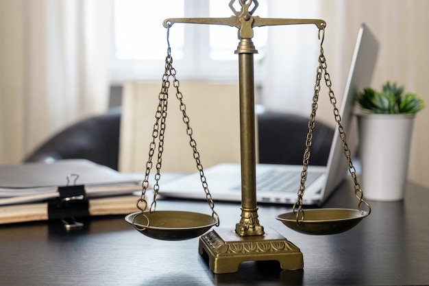 Office of Lawyer with Scales, laptop and documents on the workplace.