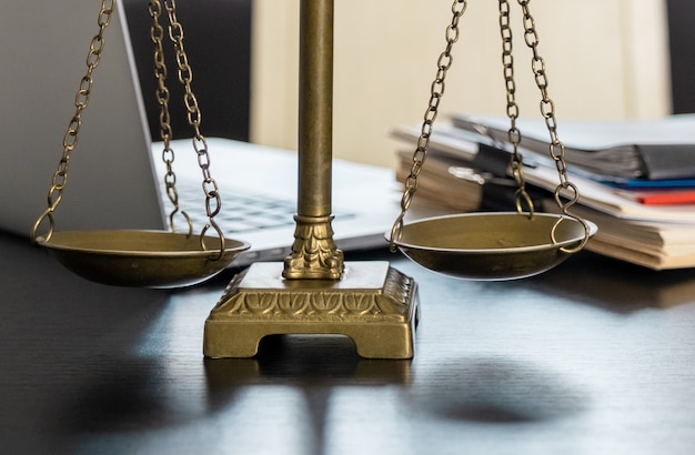 Office of Lawyer with Scales, laptop and documents on the workplace.